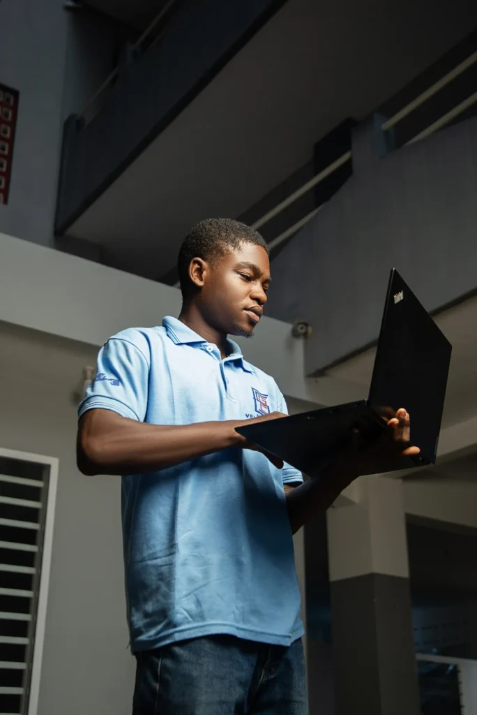 Étudiant de l’ESGC-VAK en polo bleu travaillant sur un ordinateur portable