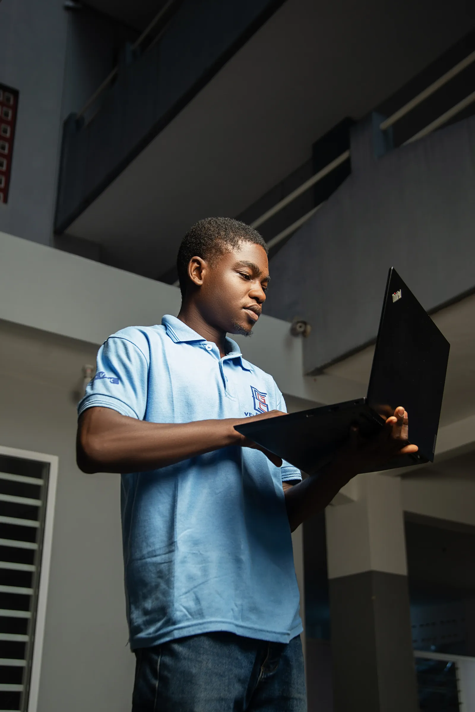 Étudiant de l’ESGC-VAK en polo bleu travaillant sur un ordinateur portable